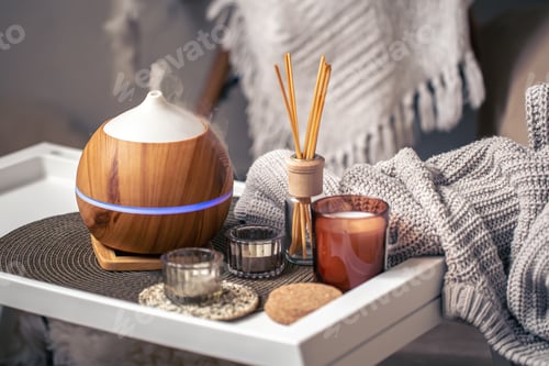 Preview: A cozy composition with an aroma diffuser and candles in a home interior.