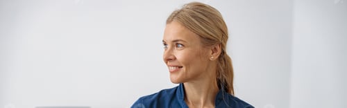 Preview: Smiling doctor, ultrasound specialist looking at side on her workplace in clinic