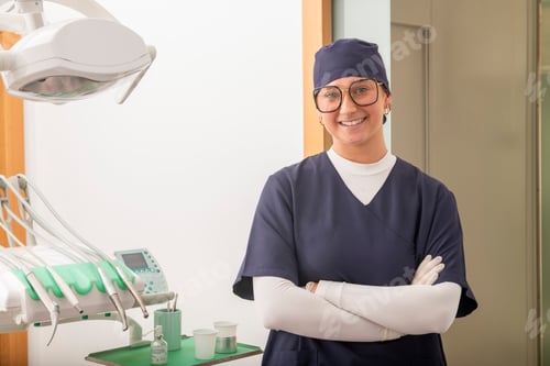 Preview: Portrait of smiling female dentist with crossed arms in dental clinic