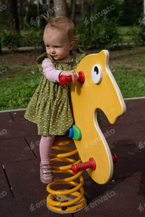 Preview: Portrait of sweet little baby girl on playground