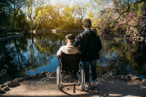 Preview: 56 year old male sitting on a wheelchair and he young friend in the park