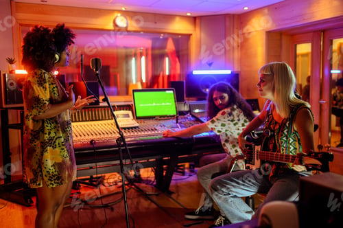 Preview: Multiracial musicians and technician in a music studio, recording session.