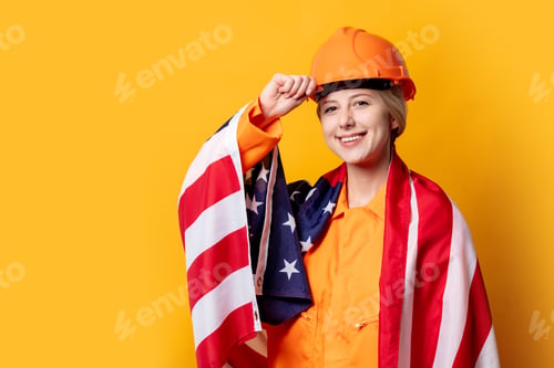 Preview: woman construction worker in helmet and orange overalls with USA flag