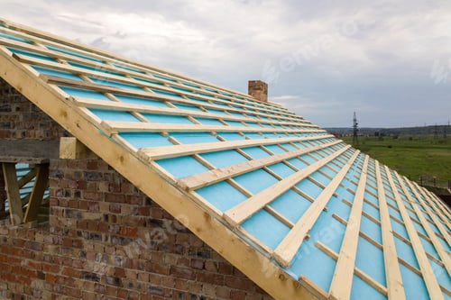 Preview: Aerial view of a brick house with wooden roof frame under construction