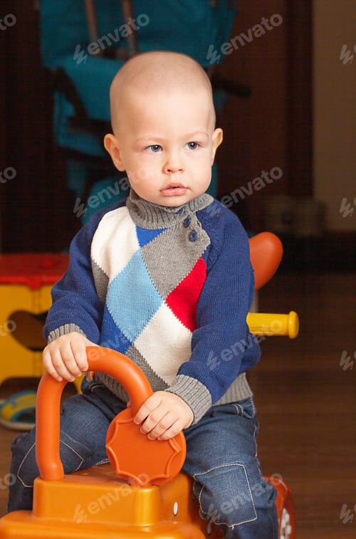 Preview: A child, a boy of one and a half years old, plays with toys, rides a toy horse