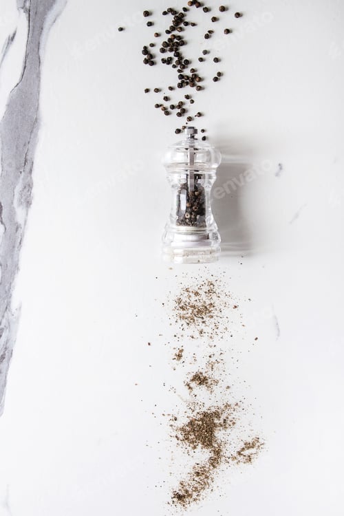 Preview: Black Peppercorns and Pepper Mill on Marble Surface