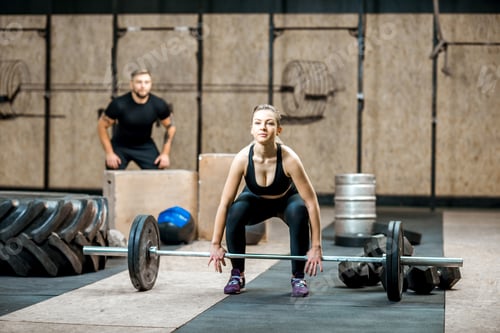 Preview: Woman lifting up a burbell in the gym