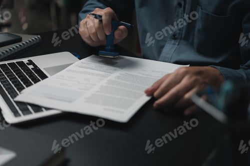 Preview: Man stamping approval of work finance banking or investment marketing documents on desk.