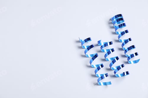 Preview: Shiny serpentine streamers on white background, above view. Space for text