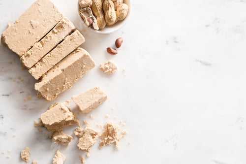 Preview: Peanut vegan dessert halva on white background.