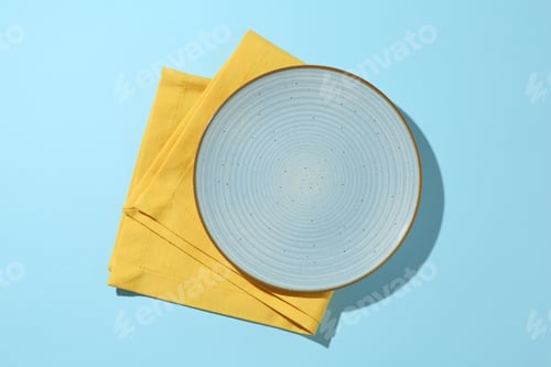Preview: Stylish plate and napkin on light blue background, top view