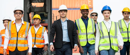 Preview: Corporate logistic team walking together at container warehouse