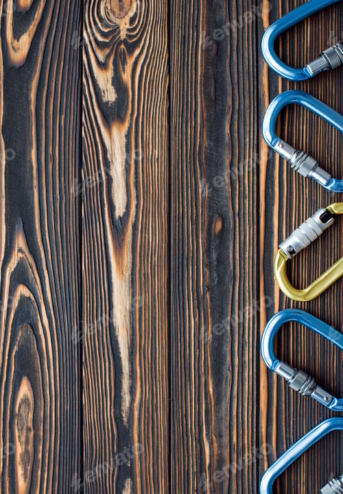 Preview: New and shiny. Isolated photo of climbing equipment. Parts of carabiners lying on the wooden table