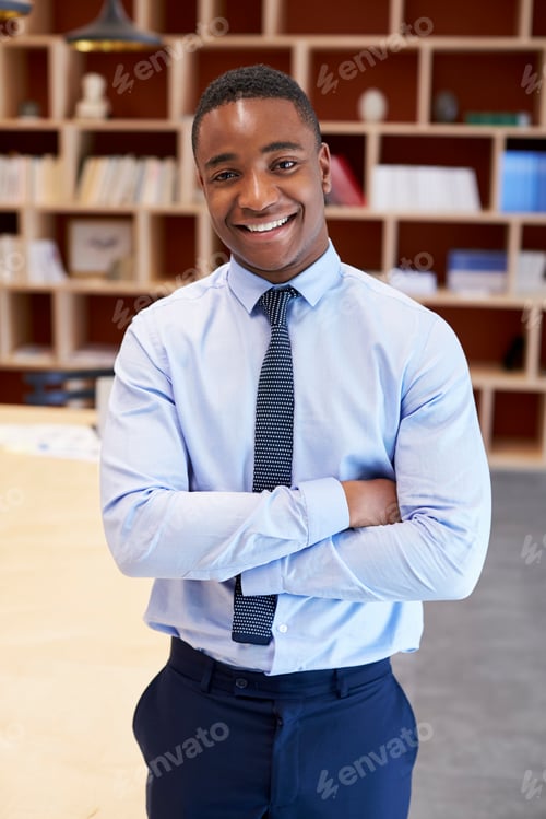 Preview: Young black man smiling to camera in a boardroom, vertical