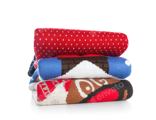Preview: Stack of warm Christmas sweaters isolated on white