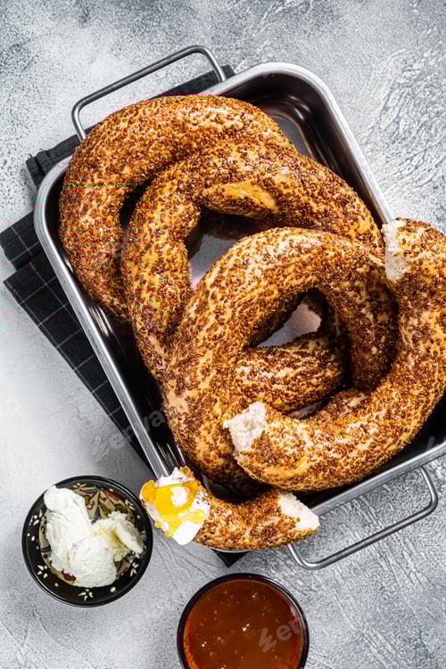 Preview: Homemade baked Turkish simit or Gevrek bagel with kaymak and honey. Gray background. Top view