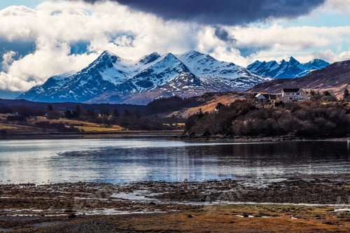 Preview: Tranquil lake surrounded by snowy majestic mountains in Isle of Skye, Scotland, UK
