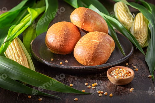 Preview: Healthy and tasty corn buns on dark table and plate.