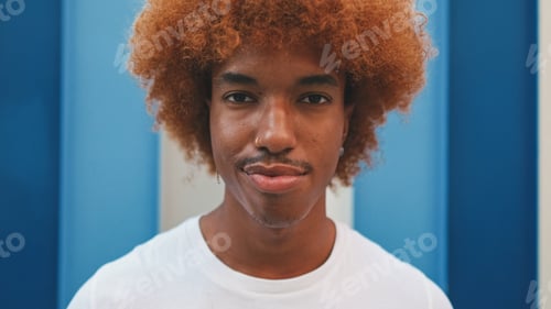 Preview: Close up, guy looks at the camera on striped wall background