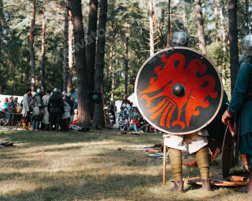 Preview: Reconstruction of medieval battle at historical festival. Back view of spearman warrior with round