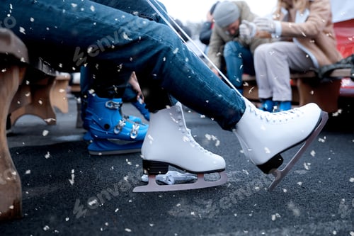 Preview: Young woman wearing white ice skates on bench outdoors, closeup