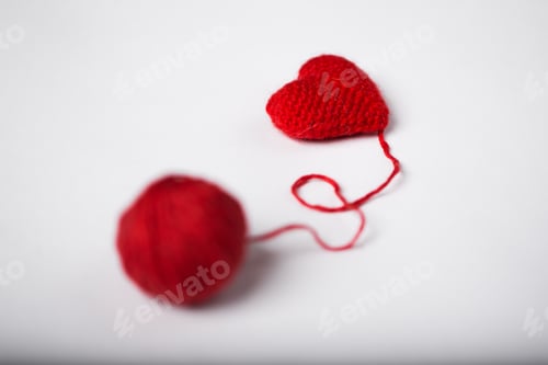 Preview: Close up of a wool ball and heart shape on white background. Heart shaped woolen yarn. Love Crochet