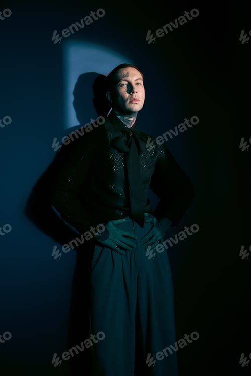 Preview: Elegant young man showcasing modern fashion in an artistic setting with dramatic lighting