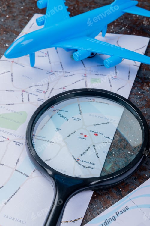 Preview: side view of black magnifying glass on a map with blue model plane on a black background
