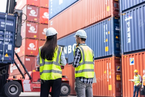 Preview: Caucasian business man and woman worker working in container terminal.