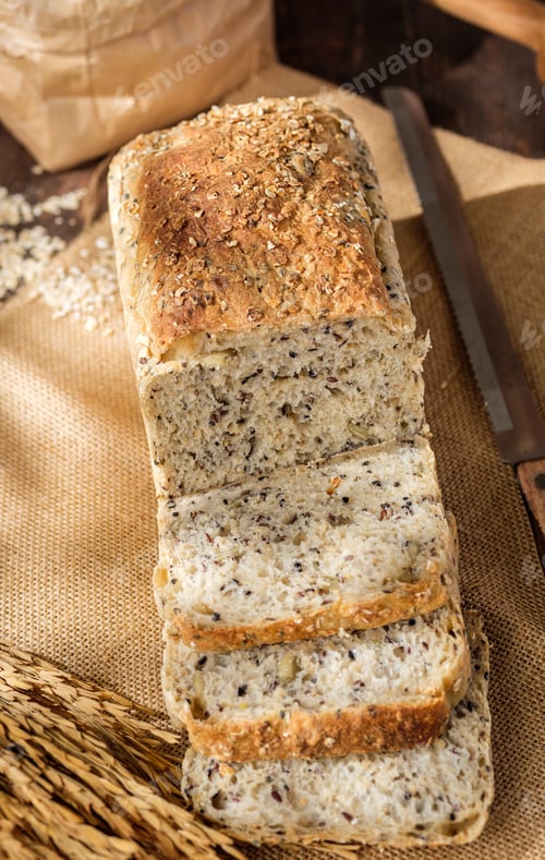 Preview: whole wheat baking bread with grains for healthy eating on wood table in kitchen