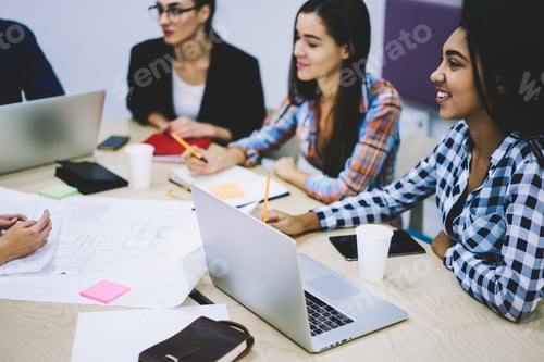 Preview: Group of multiethnic coworkers analyzing project in workspace