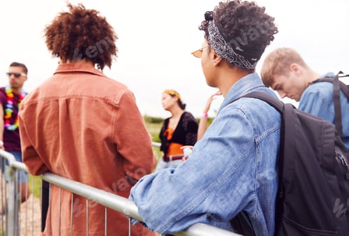 Preview: Group Of Young Friends Waiting Behind Barrier At Entrance To Music Festival Site