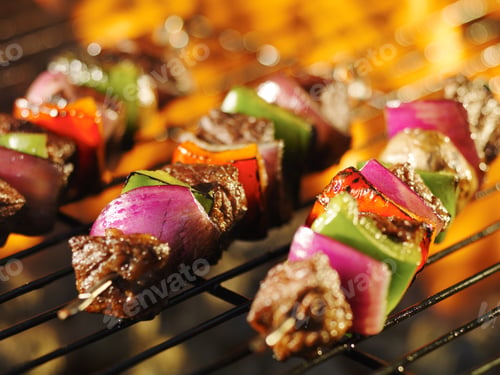 Preview: steak shishkabob skewers cooking on flaming grill