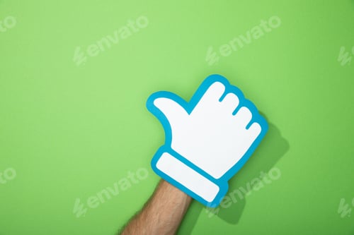 Preview: cropped view of man holding paper icon of thumb up on green