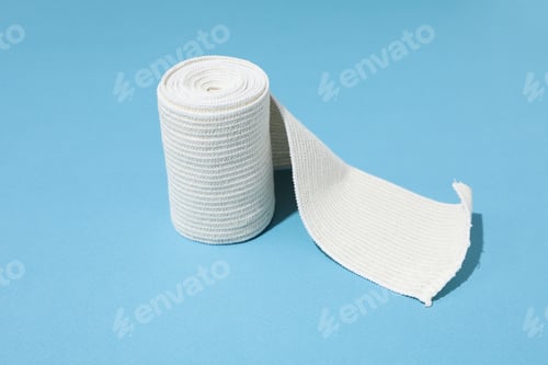 Preview: Concept of help during an injury, elastic bandage on blue background