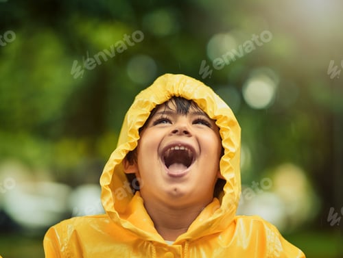 Preview: Cropped shot of an adorable little boy in the rain outside