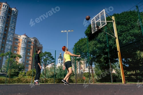 Preview: a sports ground basketball field active recreation girl with short hair in shorts and yellow T-shirt