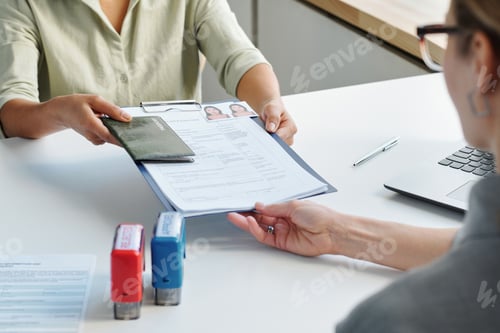 Preview: High angle view shot of unrecognizable woman applying for travel visa giving passport, application