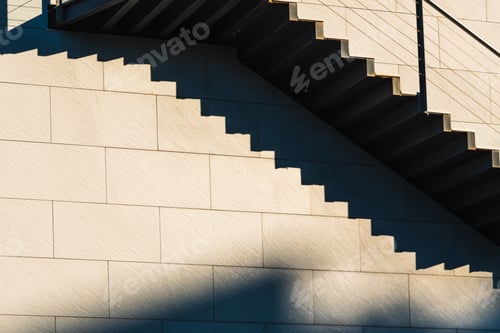 Preview: Minimalist wall with shadows from the upper steps of a modern stone staircase.