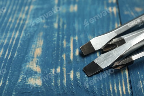 Preview: Set of screwdrivers on blue wooden table, closeup. Space for text
