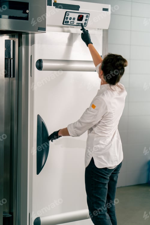 Preview: A girl cook puts the dough in the refrigerator and sets the appropriate temperature