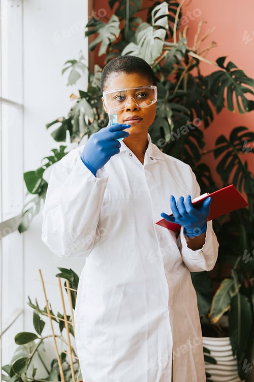 Preview: african american woman student intern with conducts an experiment with beaker and liquid