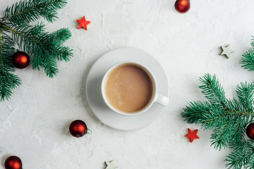Preview: A cup of coffee, fir branches and Christmas decorations on white textured background. Top view