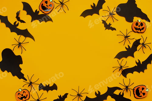 Preview: Halloween flat lay. Bats, spiders, ghost and pumpkins decoration on yellow. Happy Halloween template