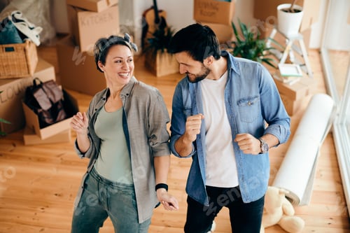 Preview: Carefree couple dancing while relocating in their new apartment.