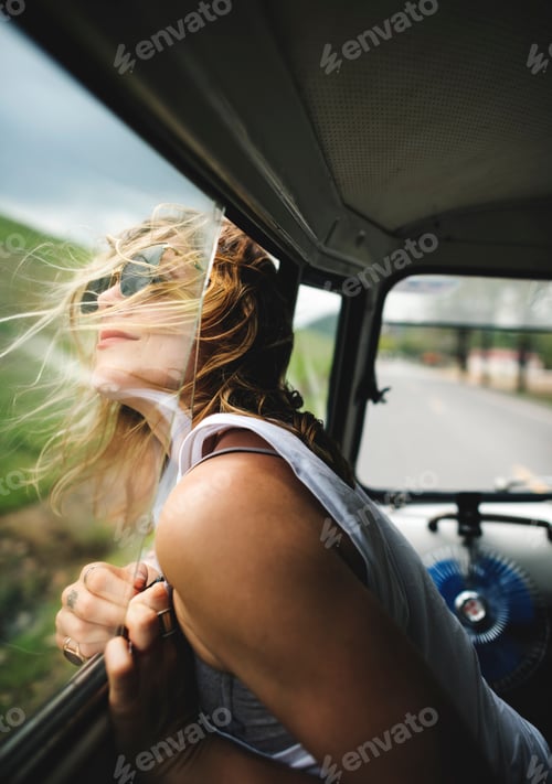 Preview: Woman Sitting in a Car Put Head Out of Window Wind Blowing Her H