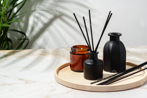 Preview: Black Reed Diffuser, Amber Candle, and Wooden Tray on White Surface