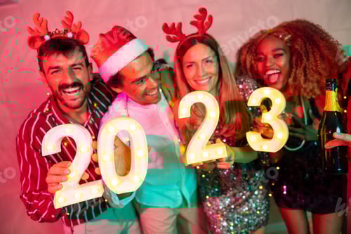 Visualização: Amigos segurando números iluminativos de 2023 na festa de Ano Novo
