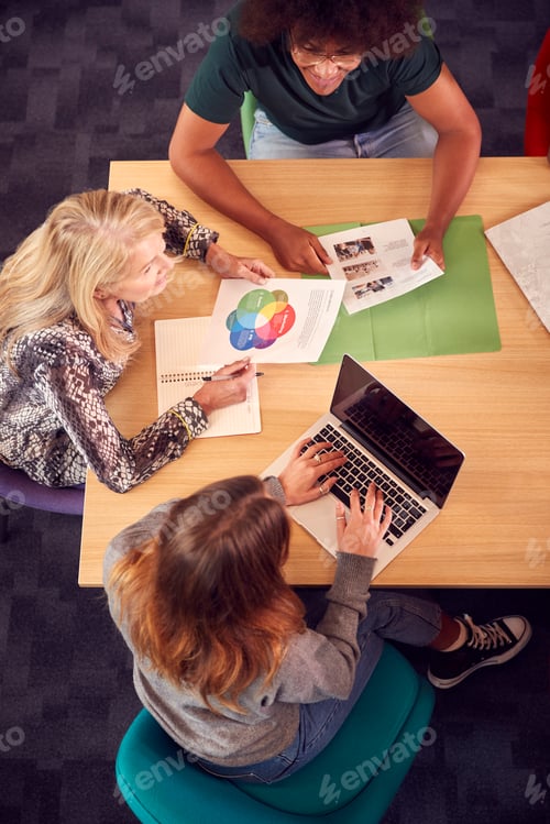Preview: Overhead Shot Of University Or College Students Sitting Around Table With Tutor In Lesson