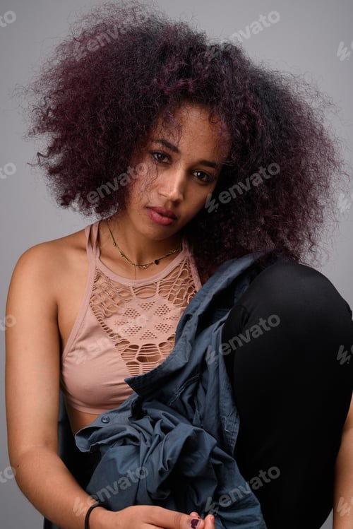 Preview: Young beautiful African woman against gray background